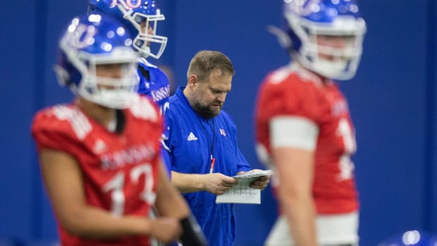 Kansas offensive coordinator Andy Kotelnicki checks his playbook during practice Tuesday in Lawrence.  